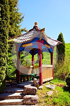 Picturesque view of wooden chinese style arbor in Zolochiv Castle. Beautiful suuny sprin day