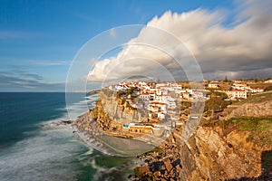 Picturesque village Azenhas do Mar. Holiday white houses on the edge of a cliff with a beach and swimming pool below. Landmark nea