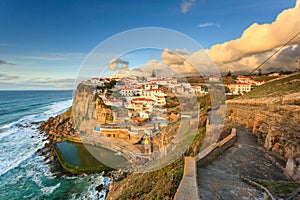 Picturesque village Azenhas do Mar. Holiday white houses on the edge of a cliff with a beach and swimming pool below. Landmark nea