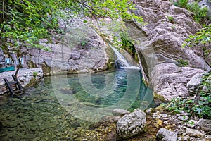 A picturesque waterfall in a cozy mountain lagoon.