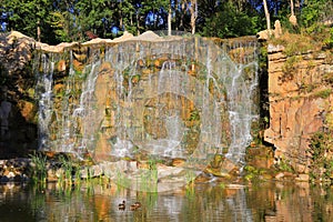 Picturesque waterfall flows among large stones in landscape in spring. Beautiful Ukrainian waterfall, Mountains and