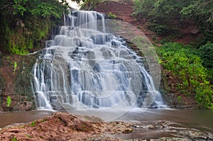 A picturesque waterfall on a mountain river. Chervonogorod waterfall on the Djuryn river in the Ternopil region, Ukraine