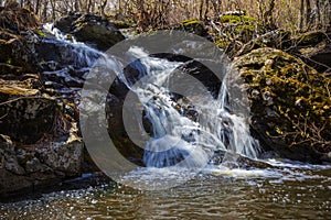 picturesque waterfall on a stream running from the mountains along a ravine