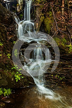 picturesque waterfall on a stream running from the mountains along a ravine