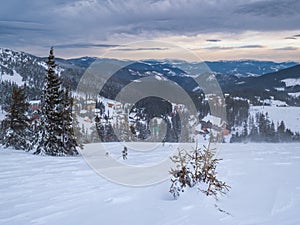 Picturesque winter windy and cloudy morning alps. View of famous Ukrainian Dragobrat ski resort from Svydovets mountain ridge