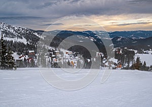 Picturesque winter windy and cloudy morning alps. View of famous Ukrainian Dragobrat ski resort from Svydovets mountain ridge