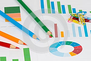 Pie and bar charts with pencils and clips