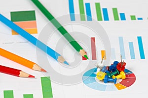 Pie and bar charts with pencils and pins