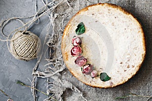 Pie from cottage cheese and bananas. Freshly baked cheesecake on rustic background. Decoration of dried flowers. Popular