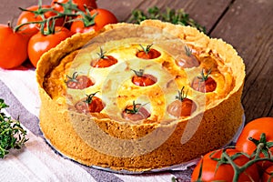 Pie with cream cheese decorated with tomatoes.