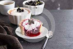 Pie with fruit and berry filling and meringue with a cup of coffee on a black background.