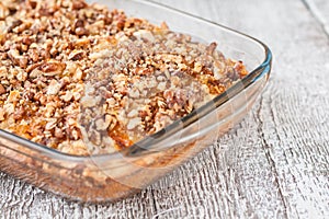 Pie with orange jam and walnuts on a wooden background