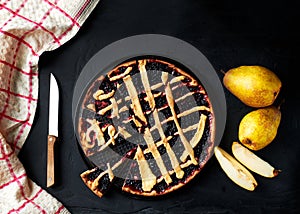 pie and pears are laid out on a black background next to a kitchen towel