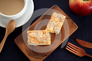 piece of Almond Apple Pound Cake on cutting board and milk coffee on wood table