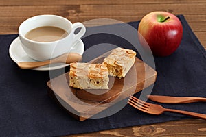 piece of Almond Apple Pound Cake on cutting board and milk coffee on wood table