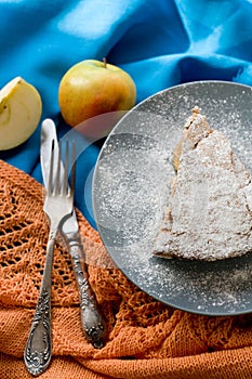 A piece of apple pie lying on blue plate, apple, cinnamon sticks