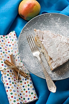 A piece of apple pie lying on blue plate, apple, fork