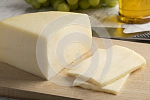 Piece of artisanal semi soft Italian Bel Paese cheese and slices photo