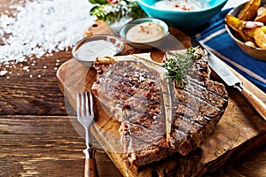 Piece of barbecued t-bone steak on wooden board