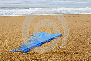 Piece of blue plastic on beach, pollution concept