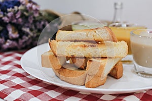 Piece of bread toast with dipping sauce on white plate.Thai Pandan mixed milk custard Custard & grilled bread.