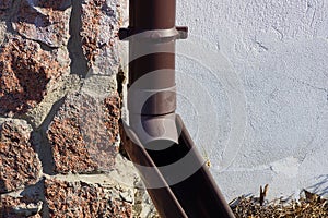 A piece of brown plastic drain pipe on the wall of a building