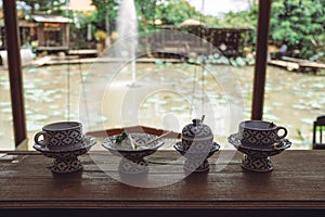 A piece of cake in an antique Thai traditional benjarong style containers with nature background