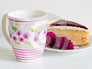 A piece of cake with beautiful mug and violet flower