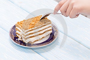 A piece of cake, a female hand with a spoon wants to eat a cake. Proper diet. diet.