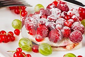 Piece of cake with fresh berries on white plate