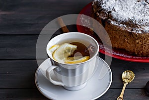 Piece of cake with fruit andcup of tea with lemon