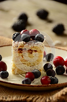 Piece of cake napoleon on a plate with sweet fresh berries