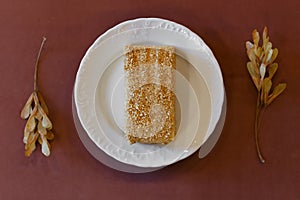 Piece of cake Napoleon on white plate decorated with dried twigs