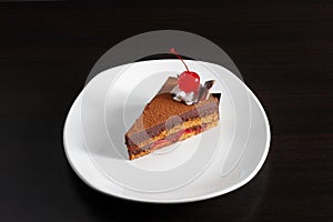 A piece of cake with a red cherry