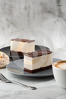 Piece of cake with souffle Bird`s milk , biscuit, mousse and dark chocolate on a dark plate, white souffle cake. Menu