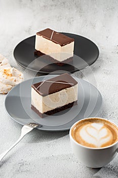 Piece of cake with souffle Bird`s milk , biscuit, mousse and dark chocolate on a dark plate, white souffle cake. Menu