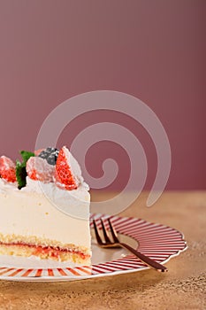 Piece of cake with strawberries, blackberries and mint on a beautiful festive plate.