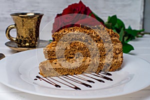 A piece of cake, white cup of tea and strawberries. Selective focus