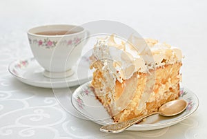 Piece of cake with white whipped cream and scattered almonds on