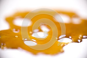 Piece of cannabis oil concentrate aka shatter isolated against w