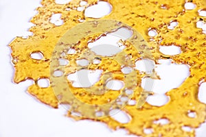 Piece of cannabis oil concentrate aka shatter isolated against w