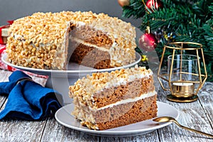 Piece of Carrot cake with cream cheese frosting and walnuts, Christmas decoration on background, horizontal