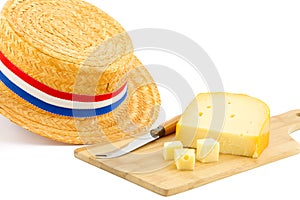 Piece of cheese on cutting board and orange hat