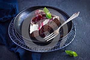 Piece of cheesecake brownie cake with cherry sauce