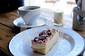 piece of cheesecake and cup of coffee on a wooden table