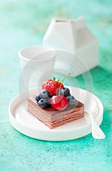 Piece of chocolate cake with fresh berries. Grain free and gluten free layers cake Napoleon