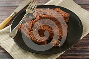 Piece of chocolate cake , fudge or pound cake. Wooden background