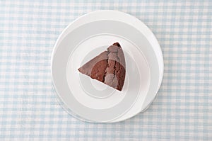 Piece of chocolate cake gateau chocola on a plate on table cloth