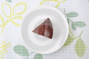 Piece of chocolate cake gateau chocola on a plate on table cloth