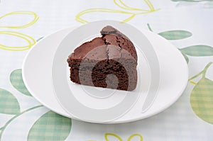 Piece of chocolate cake gateau chocola on a plate on table cloth